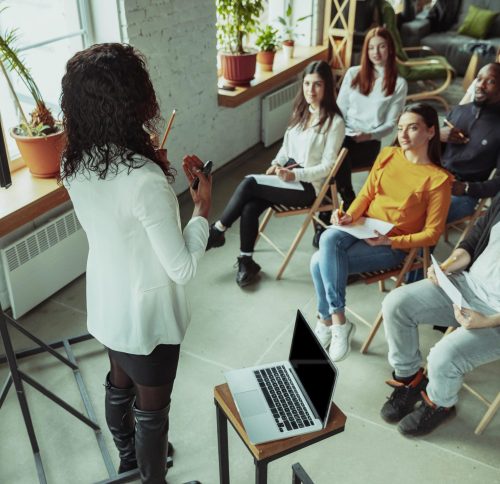 female-african-american-speaker-giving-presentation-hall-university-workshop